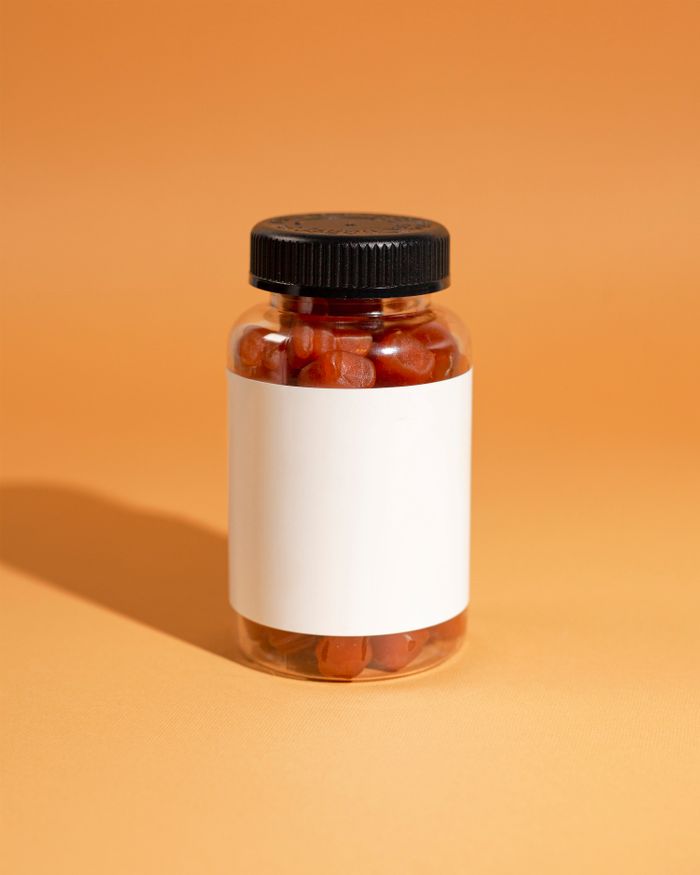 Mastering the First Impression: Your intriguing post title goes here Close-up of a jar filled with red gummies on an orange background, ideal for supplement advertising.