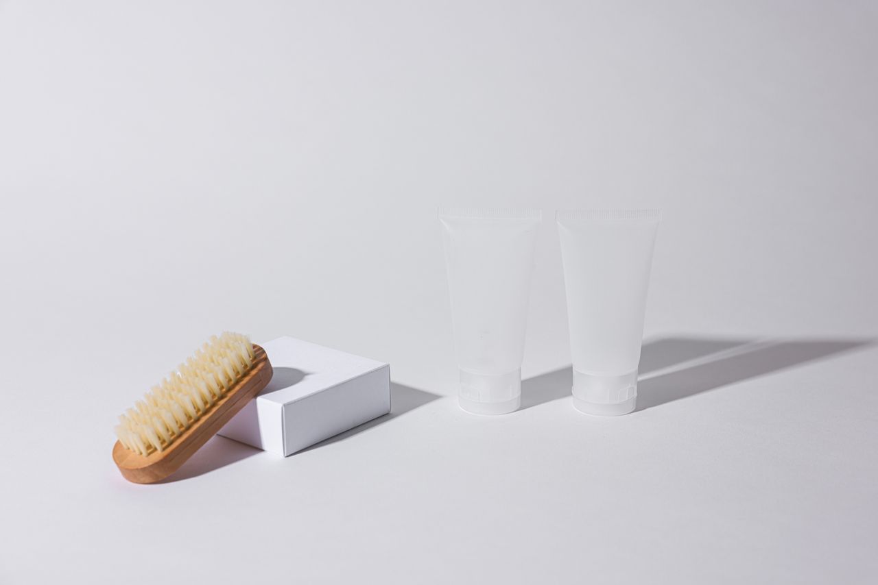 Services Simple arrangement of a brush and tubes on a white background with shadows.
